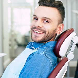 Patient smiling while sitting in dentist treatment chair