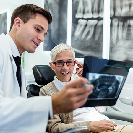 A woman reviewing X-rays with her dentist