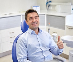 Man with thumbs up in dental chair