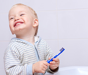 Toddler holding toothbrush