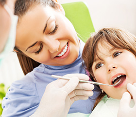 Child in mother's lap receiving checkup