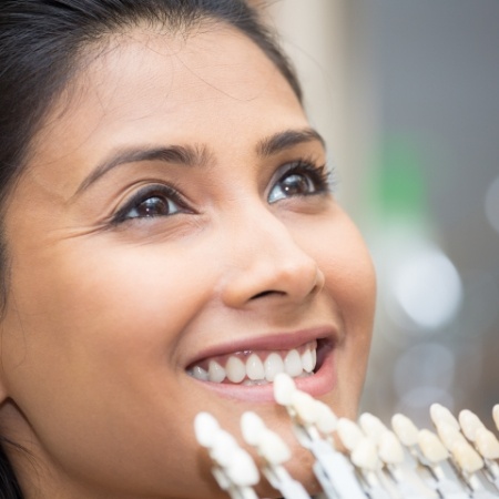 Female patient being color matched by cosmetic dentist in Port Orange