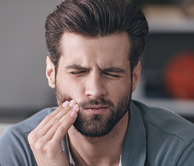 Man holding jaw in pain