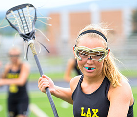 Teen girl playing lacrosse