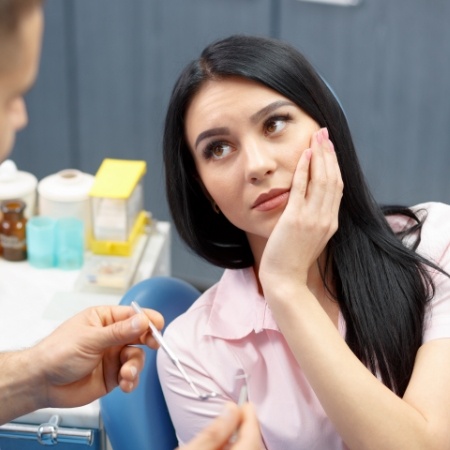 Woman with tooth pain at dentists office