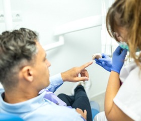 A dentist showing a mold to a male patient