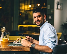 a person sitting down and eating at a restaurant