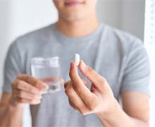 Closeup of patient holding pain medication after dental implant surgery in Port Orange