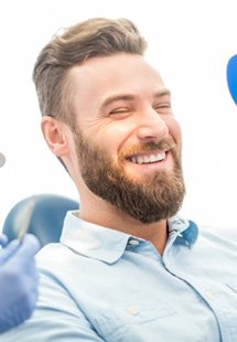 man smiling in dental mirror 