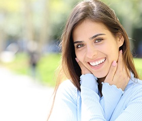 Woman in blue blouse showing off beautiful smile