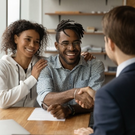 Man and woman shaking hand of man in suit