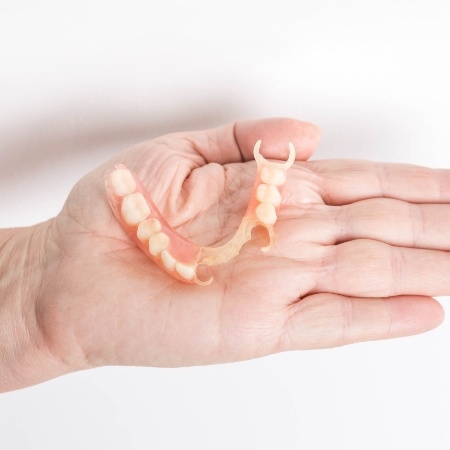 Open hand holding partial dentures in Port Orange