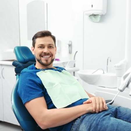 Man sitting in dental chair and smiling