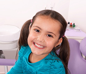 Smiling young girl in dental chair