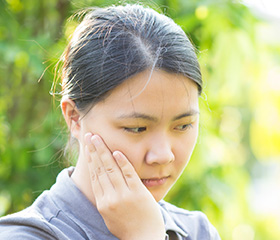 Woman holding jaw in pain