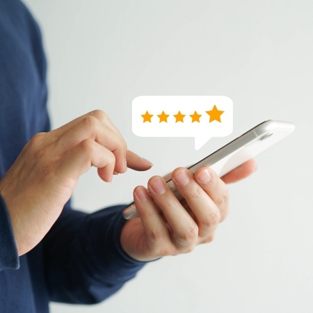 Looking at five star dental review on phone