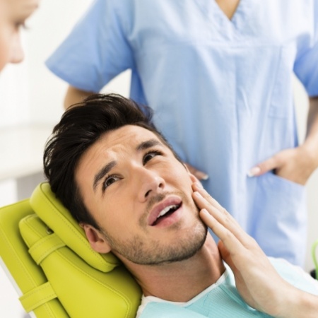 Male dental patient rubbing his jaw