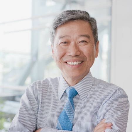 Man with tie smiling with arms folded