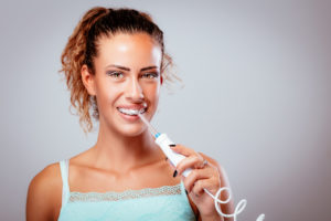 Woman with braces using water flosser