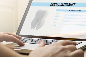 Filling out a dental insurance form on a laptop