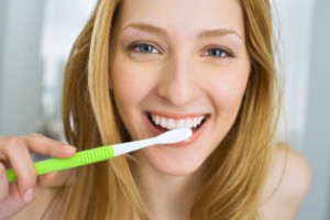 woman smiling and brushing teeth thanks to help with toothbrush options